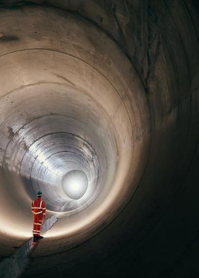 Worker standing in a sewer tunnel before operation.